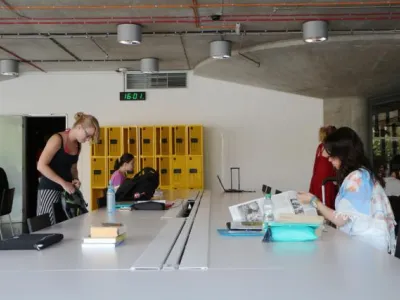 Obr.3 Stoly s integrovanými datovými a silovými zásuvkami, odkládací uzamykatelné skříňky v pozadí. Foto: Tereza Velíková, NTK Obr.3 Stoly s integrovanými datovými a silovými zásuvkami, odkládací uzamykatelné skříňky v pozadí. Foto: Tereza Velíková, NTK